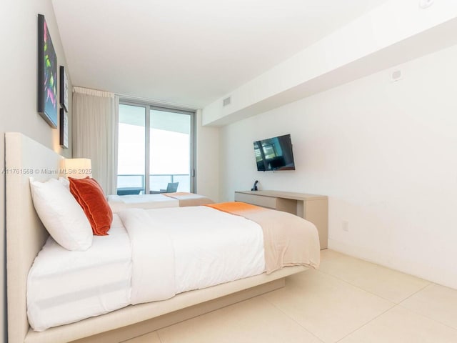 tiled bedroom featuring access to exterior, visible vents, and expansive windows