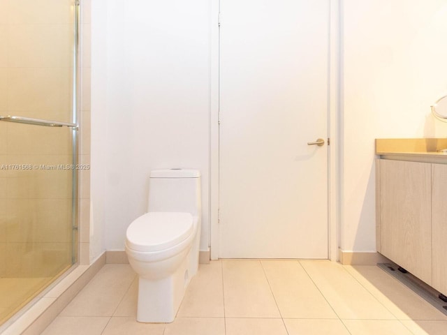 full bathroom with vanity, baseboards, a shower stall, tile patterned floors, and toilet