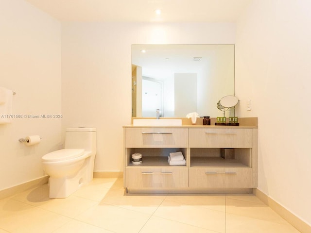 bathroom with tile patterned flooring, toilet, vanity, and baseboards