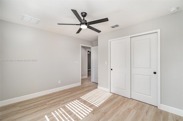 unfurnished bedroom featuring light wood finished floors, visible vents, baseboards, and a closet