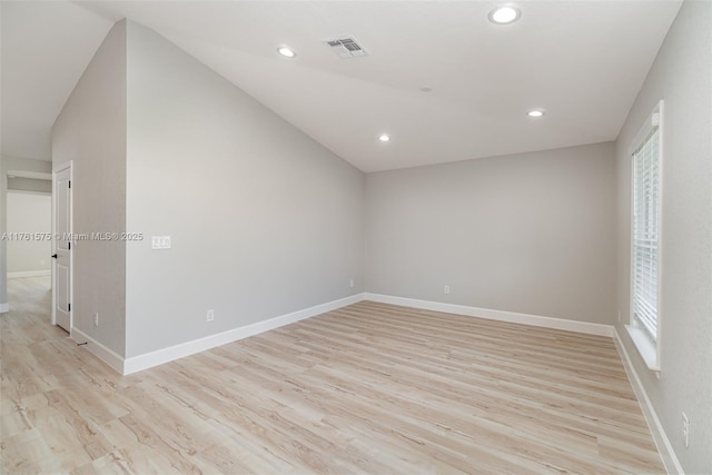 empty room featuring light wood-type flooring, visible vents, and baseboards