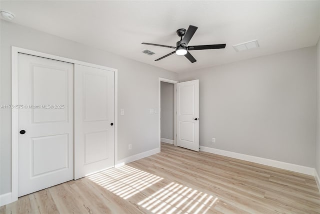 unfurnished bedroom featuring light wood-style flooring, baseboards, visible vents, and a closet