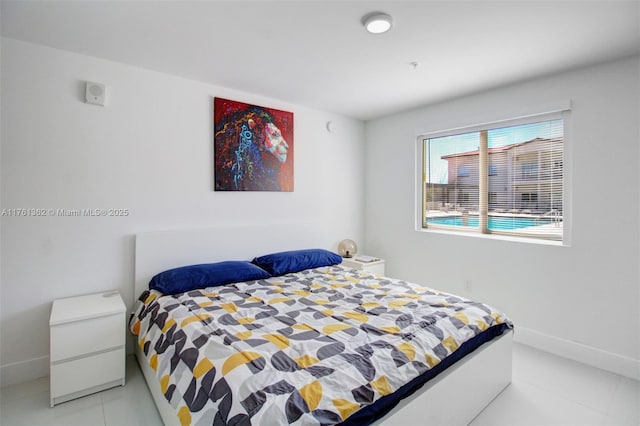 bedroom with light tile patterned floors and baseboards