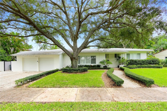 view of front of home featuring a front yard, a garage, and driveway