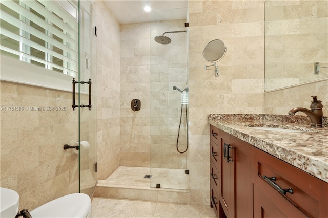 bathroom with vanity, tile walls, and a shower stall