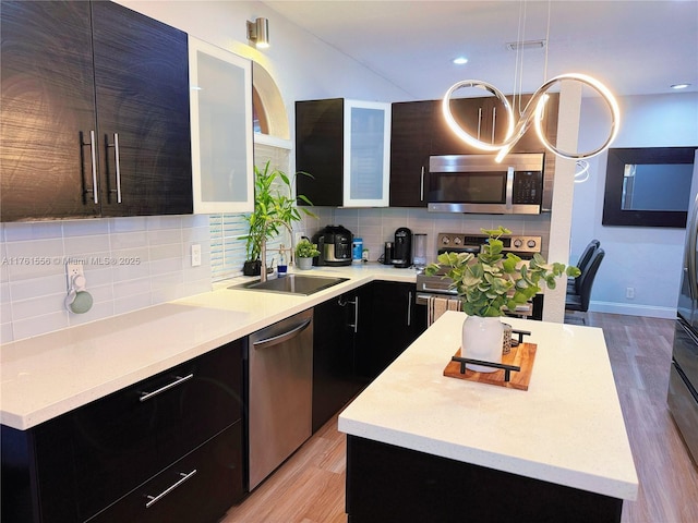 kitchen featuring a sink, stainless steel appliances, modern cabinets, and light countertops