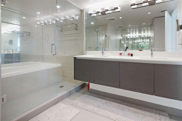 full bathroom with double vanity, a shower stall, tile patterned floors, and a sink