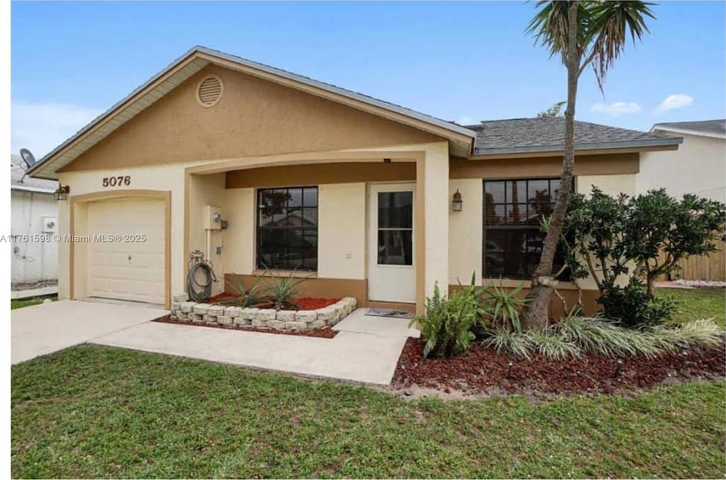 ranch-style house with a front yard, an attached garage, driveway, and stucco siding