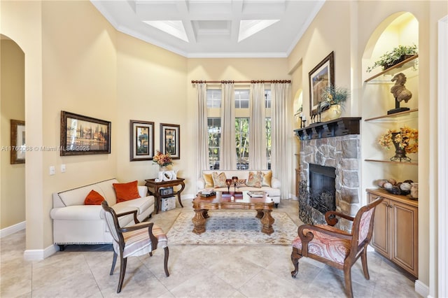 living area with coffered ceiling, baseboards, a towering ceiling, and ornamental molding