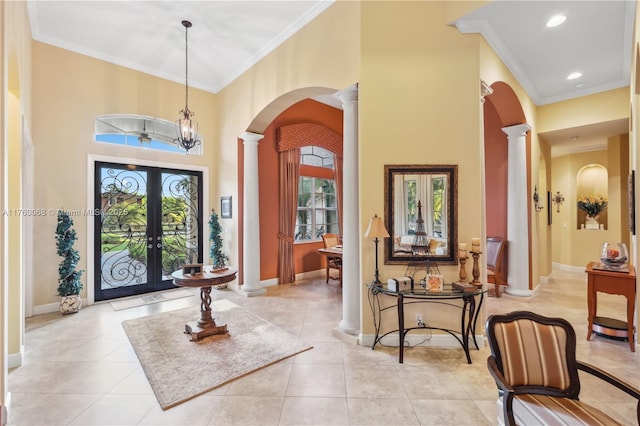 entryway with baseboards, ornamental molding, french doors, arched walkways, and ornate columns