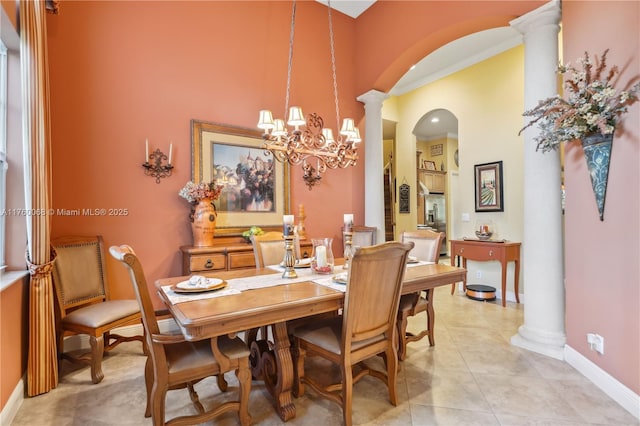 dining area featuring light tile patterned floors, baseboards, arched walkways, and ornate columns