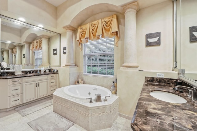 full bath with a tub with jets, ornate columns, and a sink