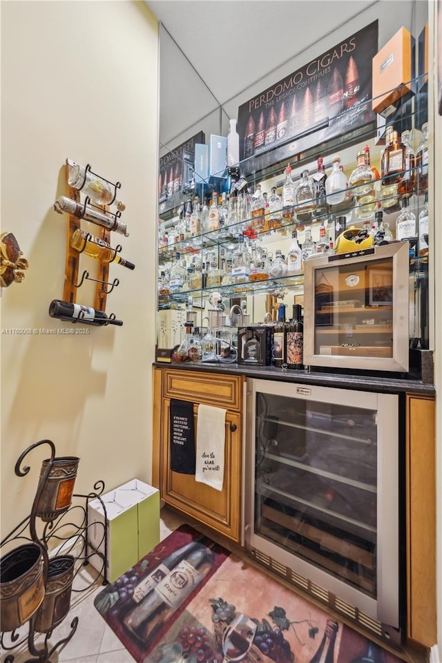 bar featuring wine cooler, tile patterned floors, and wet bar