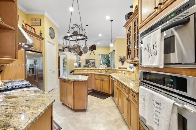 kitchen featuring ornamental molding, a sink, a peninsula, wall chimney exhaust hood, and appliances with stainless steel finishes