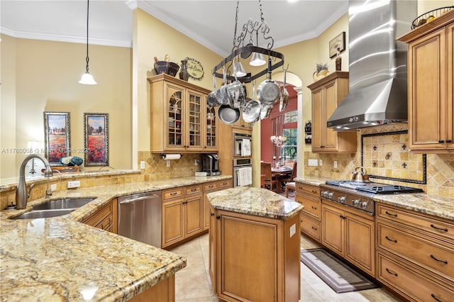 kitchen featuring ornamental molding, a sink, light stone counters, appliances with stainless steel finishes, and wall chimney range hood