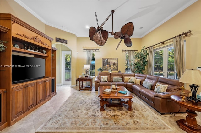 living room featuring light tile patterned floors, arched walkways, a ceiling fan, and crown molding