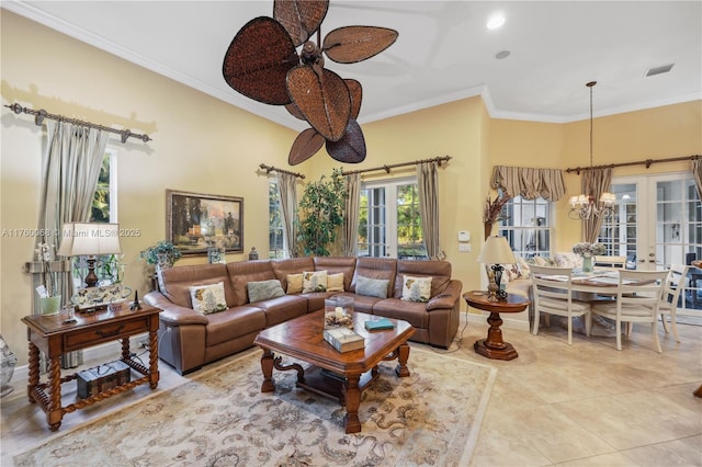 tiled living area with ceiling fan with notable chandelier, crown molding, french doors, and visible vents