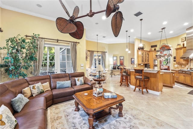 living area with ceiling fan, french doors, visible vents, and ornamental molding