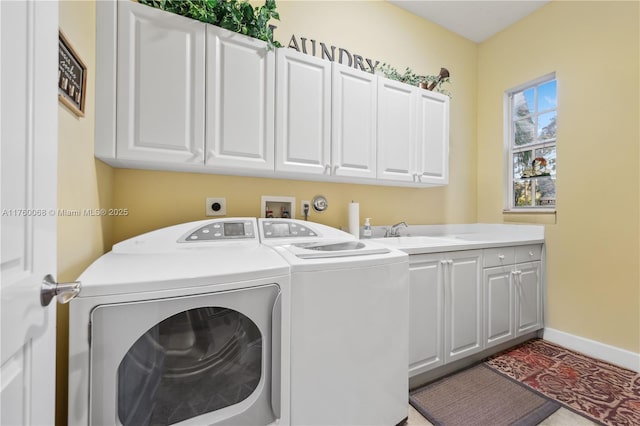 laundry area with cabinet space, washer and dryer, baseboards, and a sink