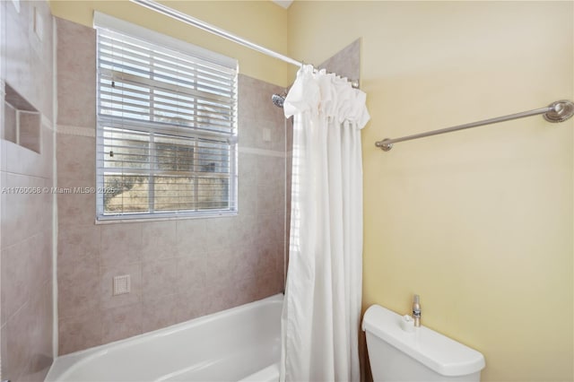 bathroom featuring toilet and shower / tub combo with curtain