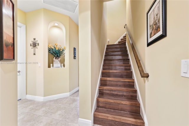 staircase with tile patterned floors, visible vents, and baseboards