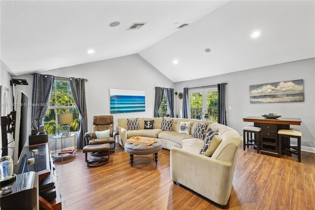 living area with recessed lighting, visible vents, wood finished floors, and vaulted ceiling