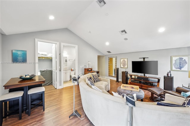 living room with lofted ceiling, recessed lighting, wood finished floors, and visible vents