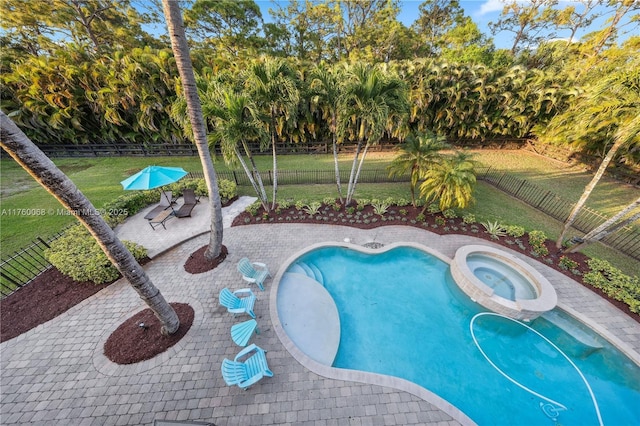 view of swimming pool with a fenced backyard, a lawn, a pool with connected hot tub, and a patio