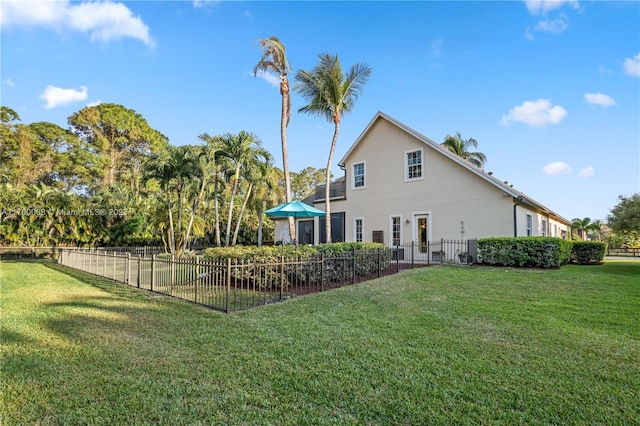 back of property with stucco siding, a lawn, and fence