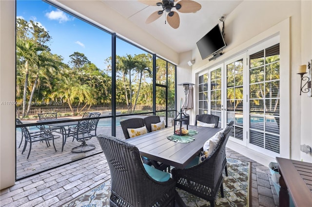 sunroom / solarium featuring a ceiling fan