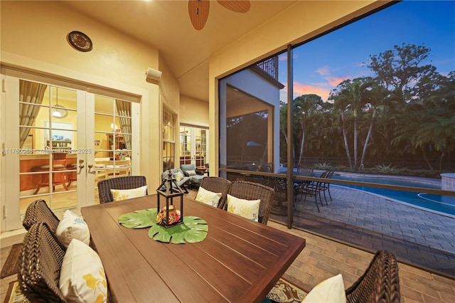 sunroom / solarium with a ceiling fan, vaulted ceiling, and french doors