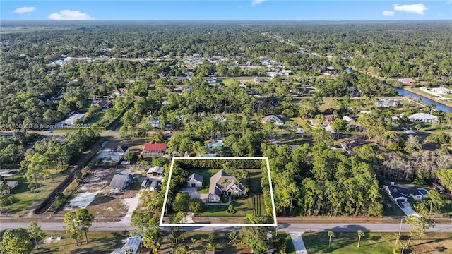 birds eye view of property featuring a forest view and a water view