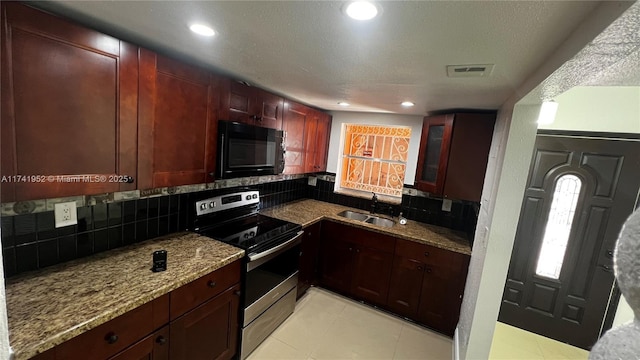 kitchen with visible vents, a sink, stainless steel range with electric cooktop, black microwave, and light stone countertops