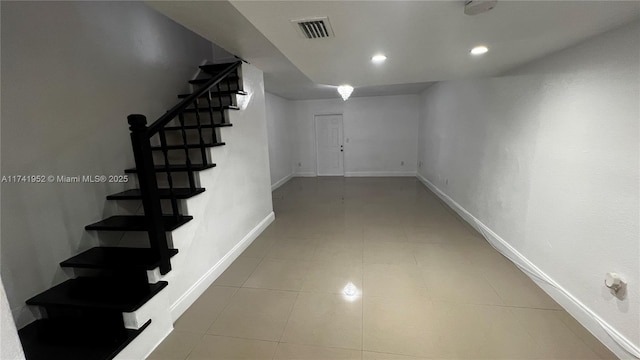 basement featuring tile patterned flooring, visible vents, baseboards, stairs, and recessed lighting