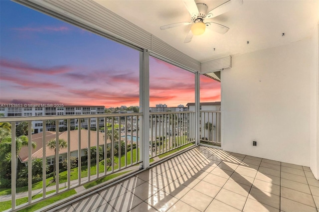 balcony at dusk featuring a ceiling fan