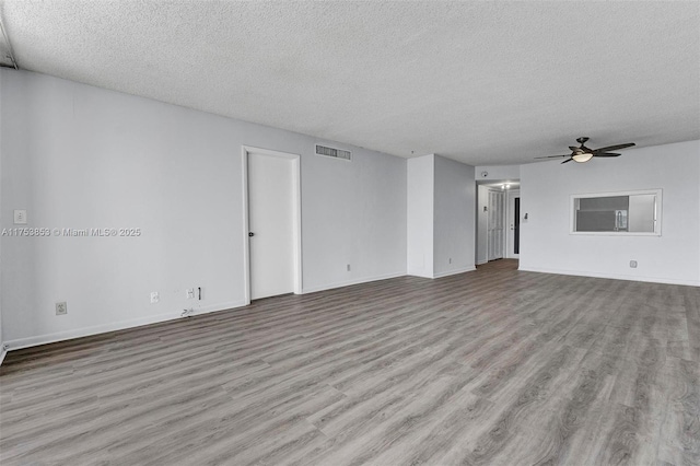 spare room featuring visible vents, a textured ceiling, a ceiling fan, and wood finished floors