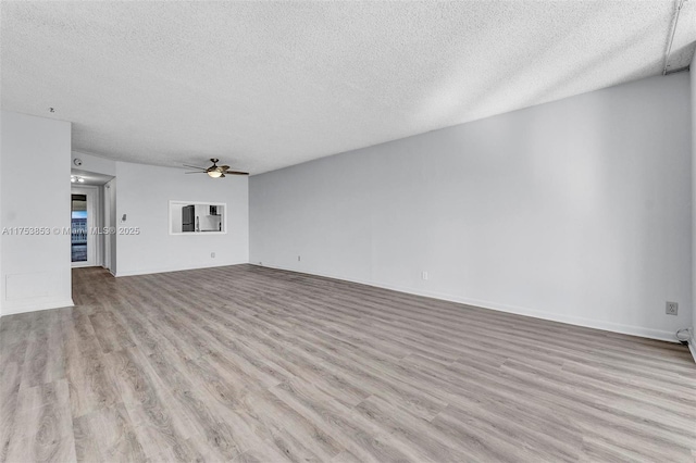 unfurnished living room featuring baseboards, wood finished floors, a textured ceiling, and ceiling fan