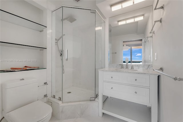 bathroom with vanity, a shower stall, and toilet