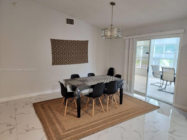 dining area with visible vents, a notable chandelier, lofted ceiling, marble finish floor, and baseboards