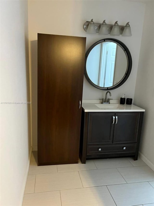 bathroom with vanity, baseboards, and tile patterned flooring