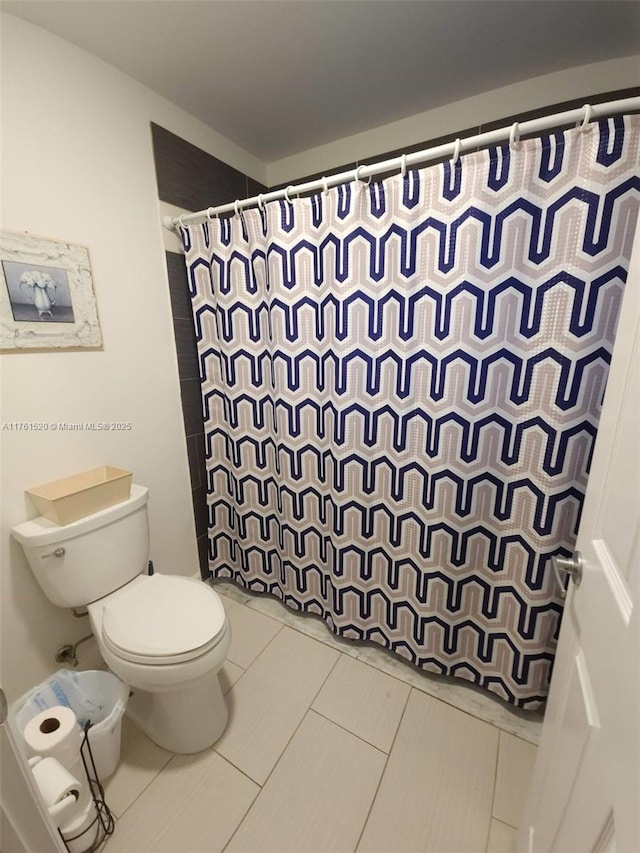 bathroom with toilet and a shower with curtain