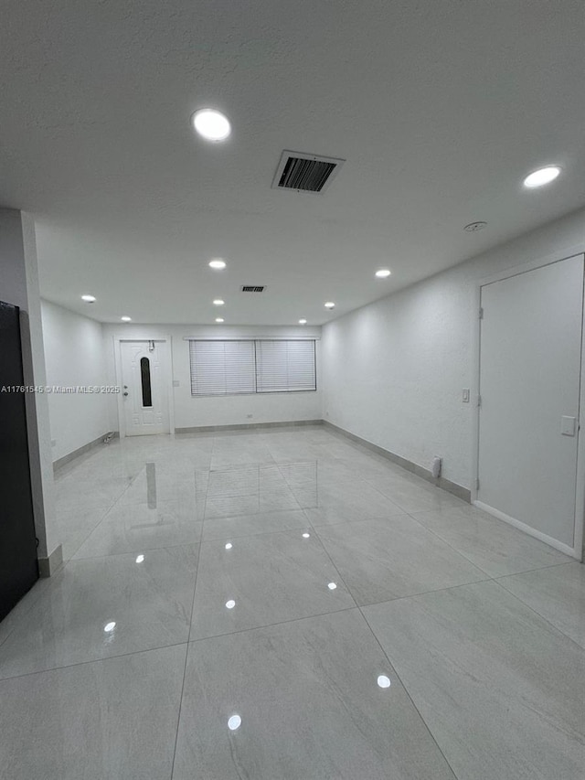 spare room featuring visible vents, recessed lighting, and baseboards