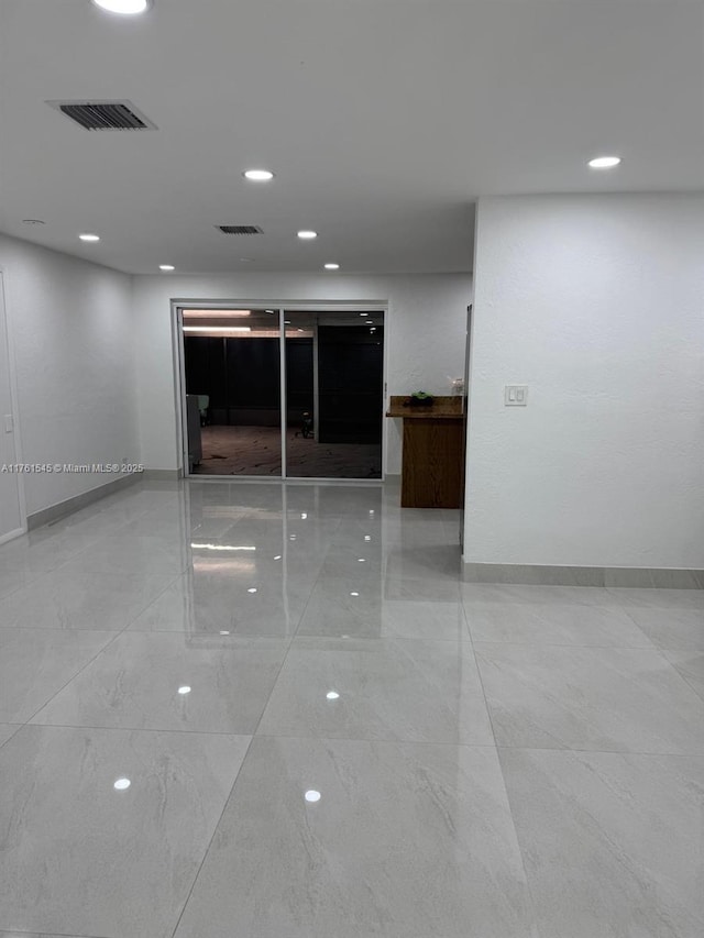 spare room with recessed lighting, visible vents, and baseboards