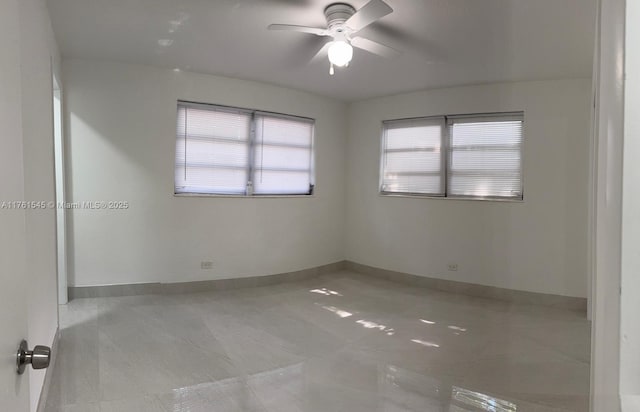 unfurnished room with baseboards and a ceiling fan