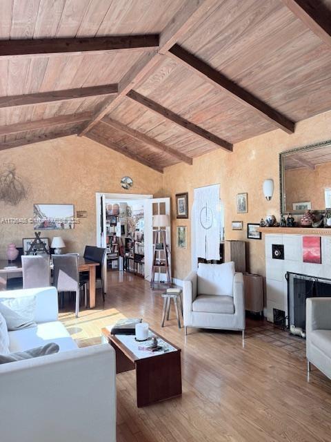 living room featuring wooden ceiling, vaulted ceiling with beams, and wood finished floors