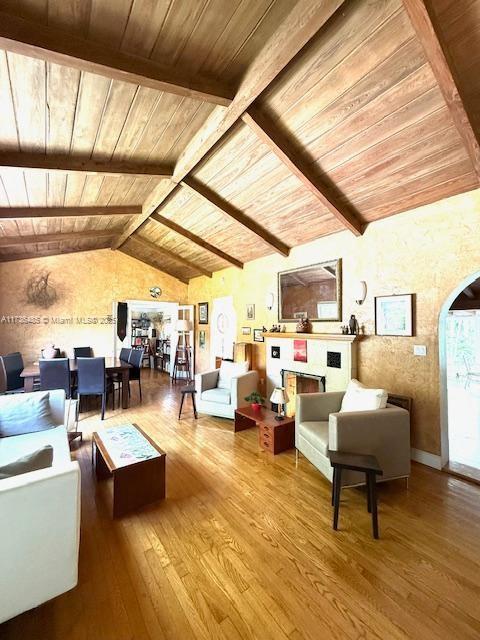 1643 Nethia Dr, Miami, FL 33133 - living room featuring wooden ceiling, hardwood / wood-style floors, a fireplace, and arched walkways