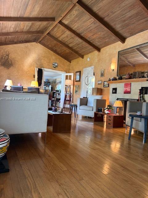 living area with dark wood-style floors, beamed ceiling, wood ceiling, and high vaulted ceiling