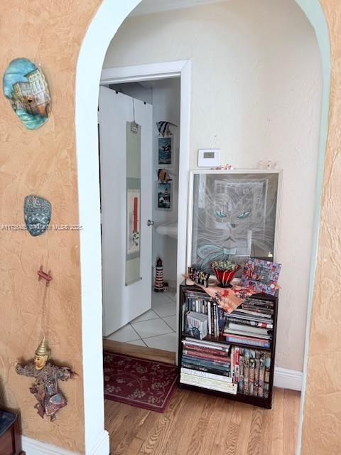 1643 Nethia Dr, Miami, FL 33133 - hallway with arched walkways, wood finished floors, and baseboards
