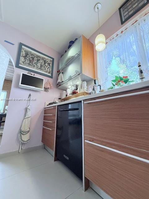 kitchen featuring brown cabinetry, baseboards, light countertops, hanging light fixtures, and modern cabinets