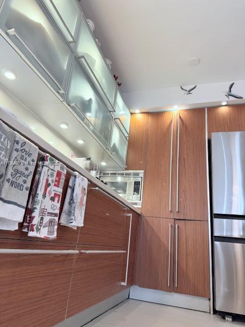 1643 Nethia Dr, Miami, FL 33133 - kitchen with stainless steel appliances and brown cabinets